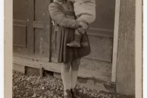 1944_Francesca con in braccio il fratello minore di fronte al Bar Nicola di via Giambellino 151 (Fonte Francesca Caputo_ Giambellino 151)